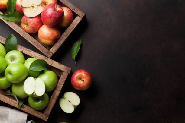 istock Green and red apples in wooden box 1011714702