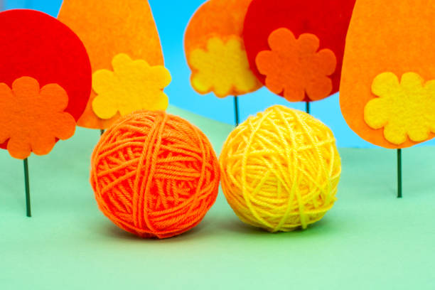 A stack of bright, multicolored yarn balls is prominently displayed, showcasing different hues and textures, ideal for knitting and crafting enthusiasts.