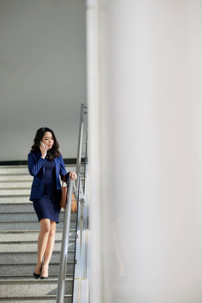 istock Stylish woman standing on stairs 1011725166