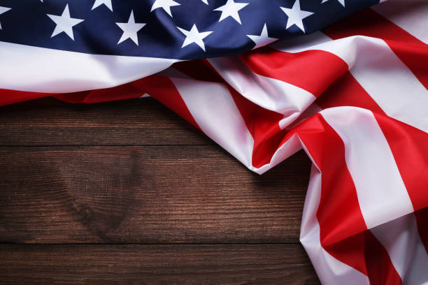 istock American flag on brown wooden table 1011728106