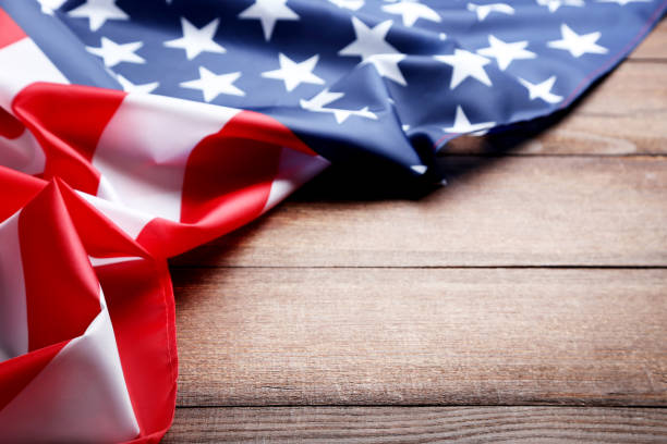 istock American flag on brown wooden table 1011728370