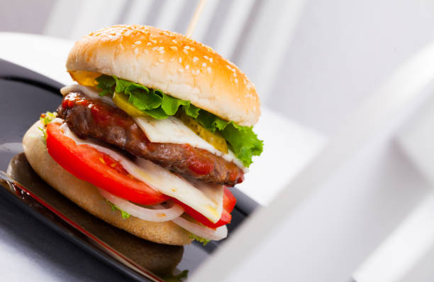istock Delicious tasty burger with beef cutlet, fresh vegetables and cheese 1011728470