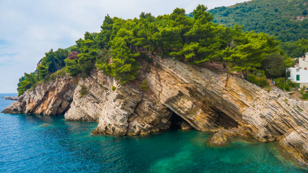 istock View on rocky grotto with pine trees on top and turquoise water 1011728568