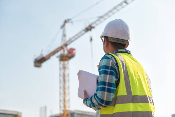 Civil engineer inspects work using radio communication with the management team in the construction area.