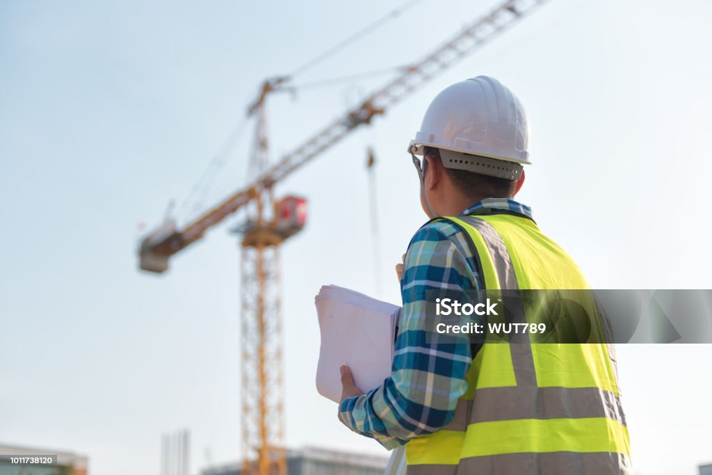 Civil engineer inspects work using radio communication with the management team in the construction area. Foreperson Stock Photo