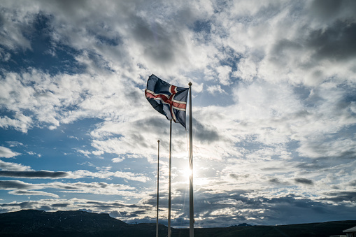 Icelandic flag against sky and sun 2018