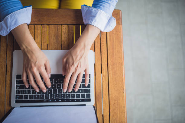istock Female hands typing on laptop keyboard at cafe 1011743772