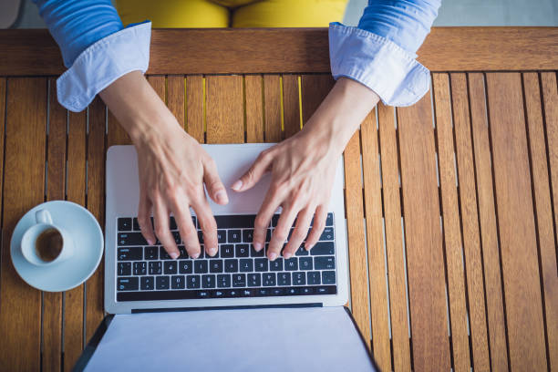 istock Female hands typing on laptop keyboard at cafe 1011743792