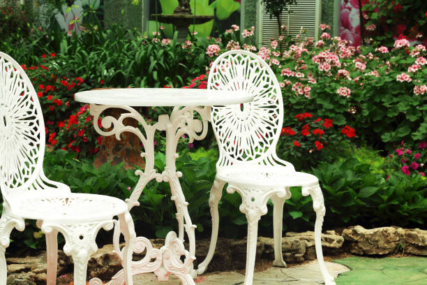 istock White chairs and round table in the flowers garden. 1011746110