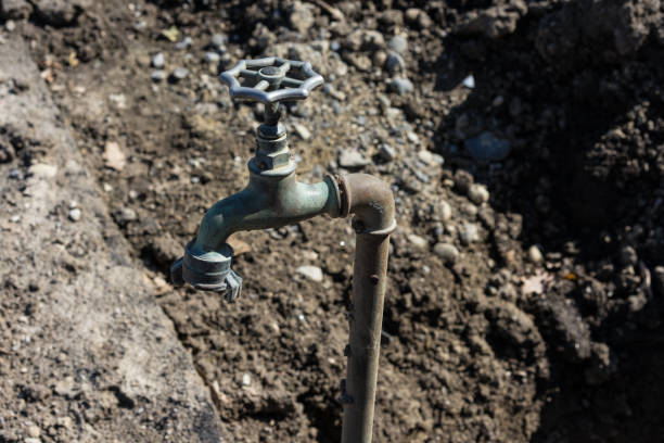 old water faucet in garden with earth