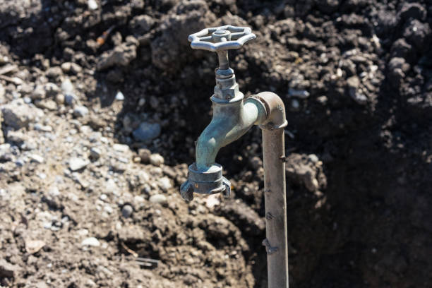 old water faucet in garden with earth