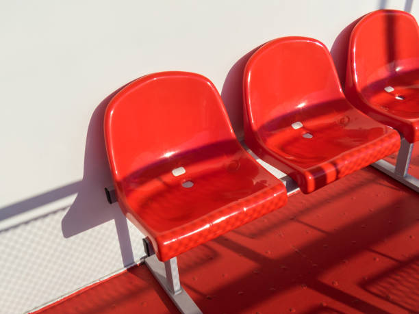 istock Red plastic chairs in front of a white wall 1011746932