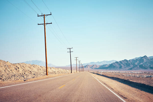 istock Desert road with wooden electricity posts. 1011756192