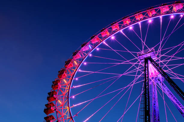 istock Big ferris wheel with festive colorful illumination 1011756704