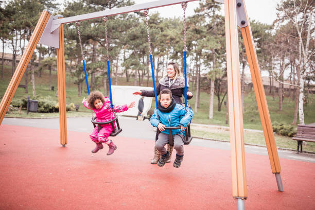 istock Mixed race children playing with mother in public park 1011762506