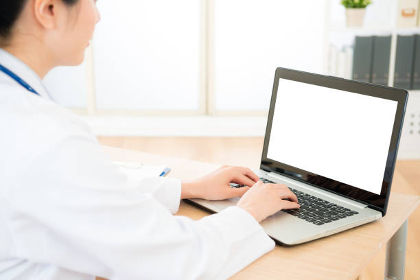 istock pretty elegant woman doctor using mobile laptop 1011771110