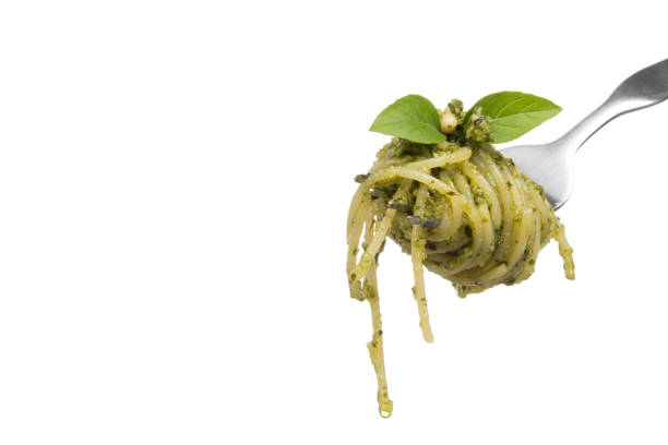 спагетти с домашним соусом песто дженовезе на вилке, изолированном на белом фоне - pesto sauce italian culture pine nut photography стоковые фото и изображения