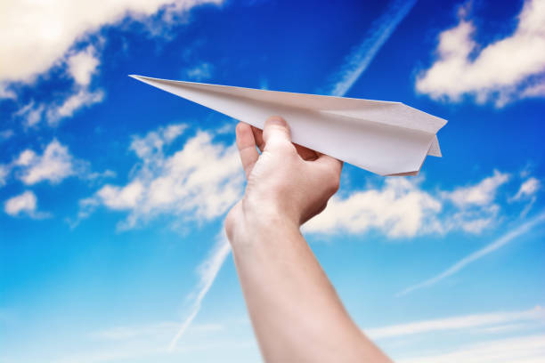 istock Paper airplane in front of blue sky with copy space 1011772820
