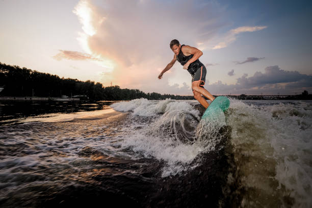 istock Young wakesurfer riding on river waves in the evening 1011775382