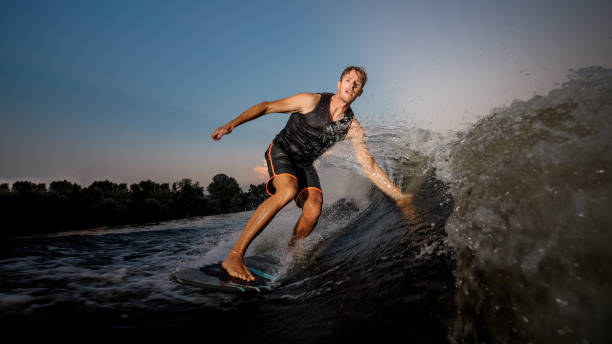 istock Active strong young man riding down the river waves in evening 1011776118
