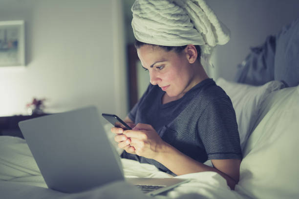 junge frauen, die überstunden zu hause mit laptop - nasses haar stock-fotos und bilder