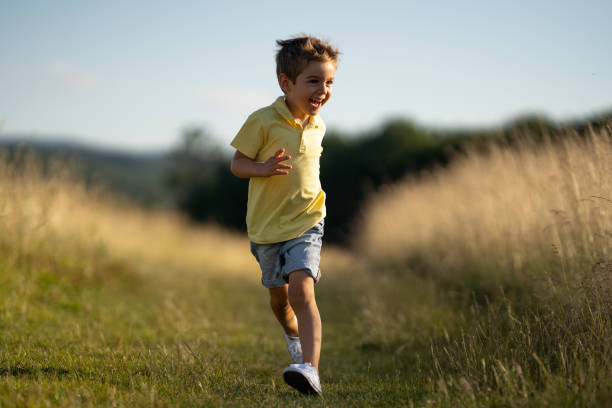 istock little cheerful boy running in grassland 1011782168