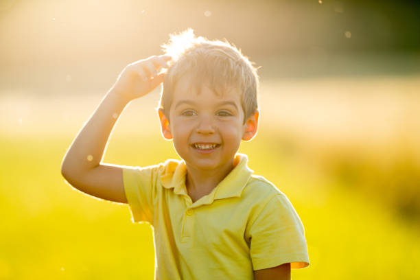 istock cute happy smiling little boy in summer sunshine backlight grassland 1011782324