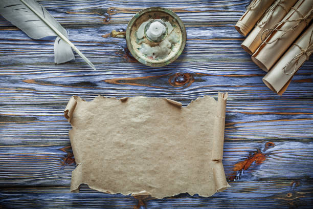 istock Vintage paper scrolls feather candleholder on blue wooden backgr 1011788880