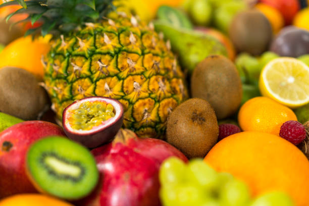 many sliced raw fruits on other colorful produce perfect background for healthy vegetarian or vegan living themes color surge trend
