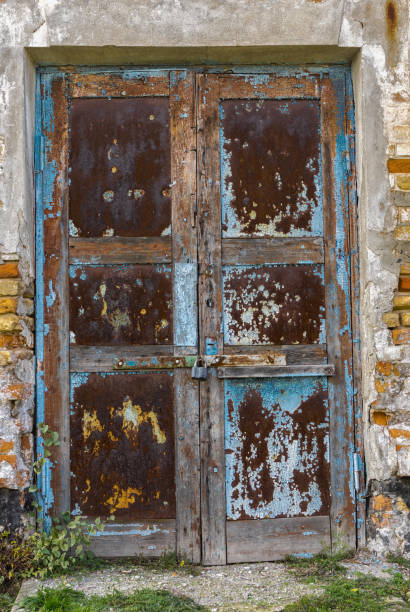 istock Old architectural details - rusty door in an ancient building locked with small rusty padlock 1011792038