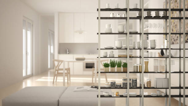 istock Kitchen living room shelving system foreground close-up, interior design concept, white modern room open plan in the background 1011792296