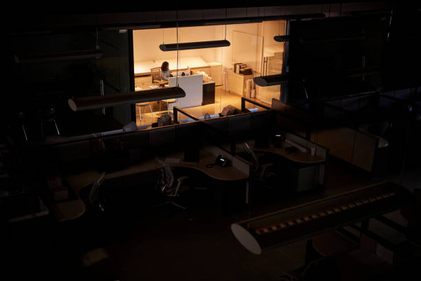 istock Office worker working late in an otherwise dark office 1011792692