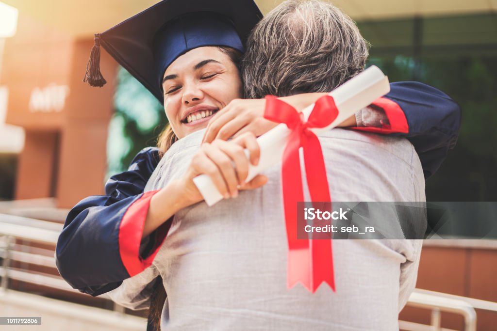 Graduated student hugging her father Graduation Stock Photo