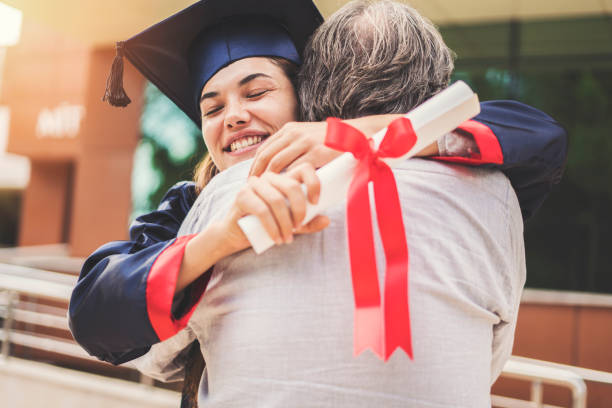 студентка обнимая отца - mortar board child female people стоковые фото и изображения