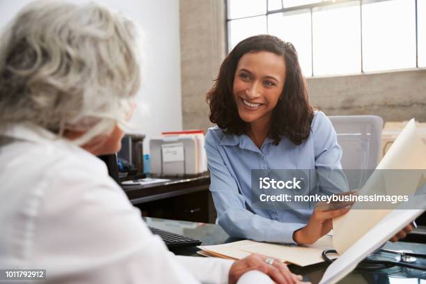 Smiling Female Analyst In Consultation With Senior Woman Stock Photo - Download Image Now