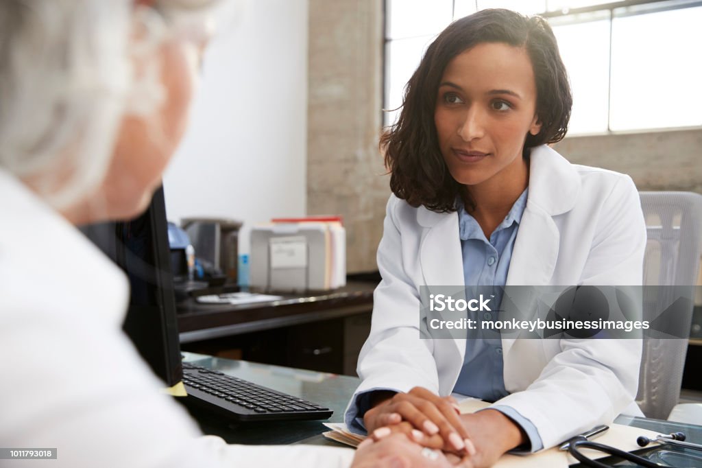 Jeune femme médecin en consultation avec le patient senior - Photo de Docteur libre de droits