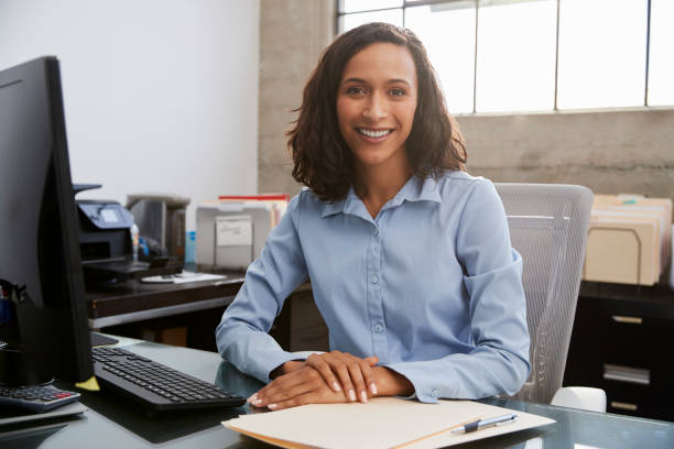 事務所の机に座っている若い女性プロ - professional occupation business one person young adult ストックフ��ォトと画像