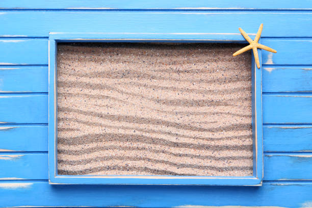 istock Blue wooden frame on beach sand 1011796442