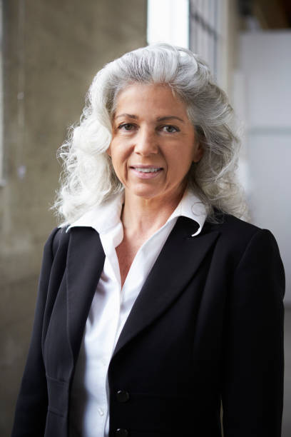 istock Senior white businesswoman smiling to camera, vertical 1011796880