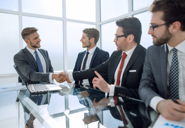 istock handshake financial partners over the negotiating table 1011808876