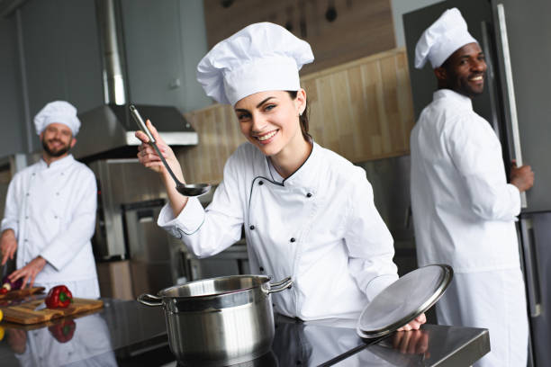 istock Female chef tasting dish by her multiracial team 1011810528