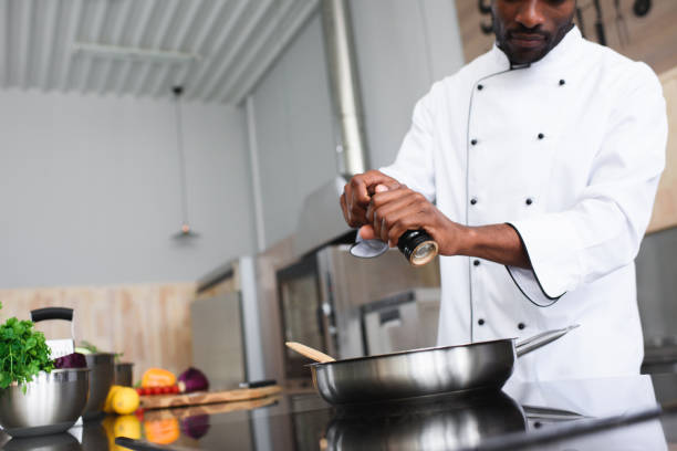 istock African american chef seasoning dish by kitchen stove 1011810546