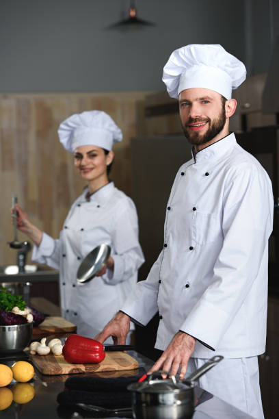 istock Professional chefs man and woman cooking in restaurant kitchen 1011810664