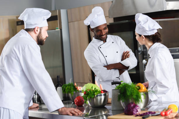 istock Multiracial chefs team discussing new recipe by kitchen counter 1011813040