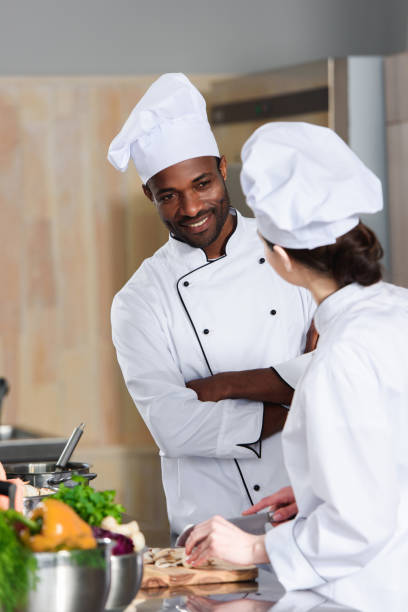 istock Multiracial team of cooks talking while cooking on modern kitchen 1011813106
