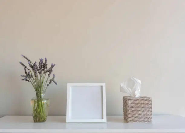 Photo of Blank square picture frame with lavender and tissues on shelf