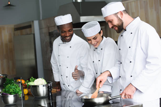 istock multicultural chefs frying vegetables on frying pan at restaurant kitchen 1011819390