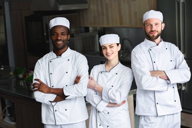 istock smiling multicultural chefs standing with crossed arms at restaurant kitchen 1011819550