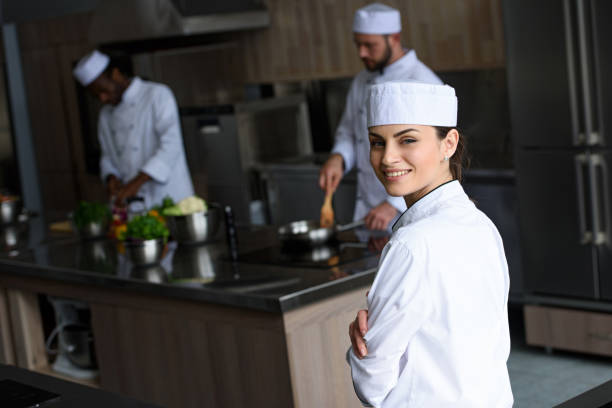 istock smiling beautiful chef looking at camera at restaurant kitchen 1011819656