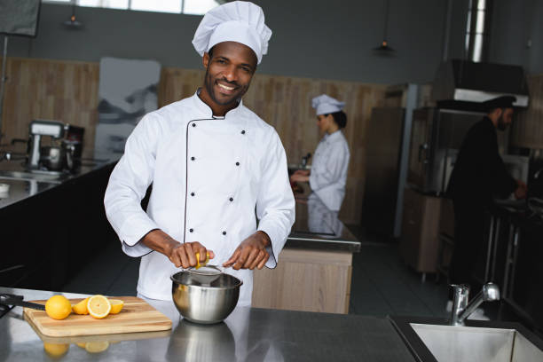 istock smiling handsome african american chef squeezing lemons at restaurant kitchen 1011819966